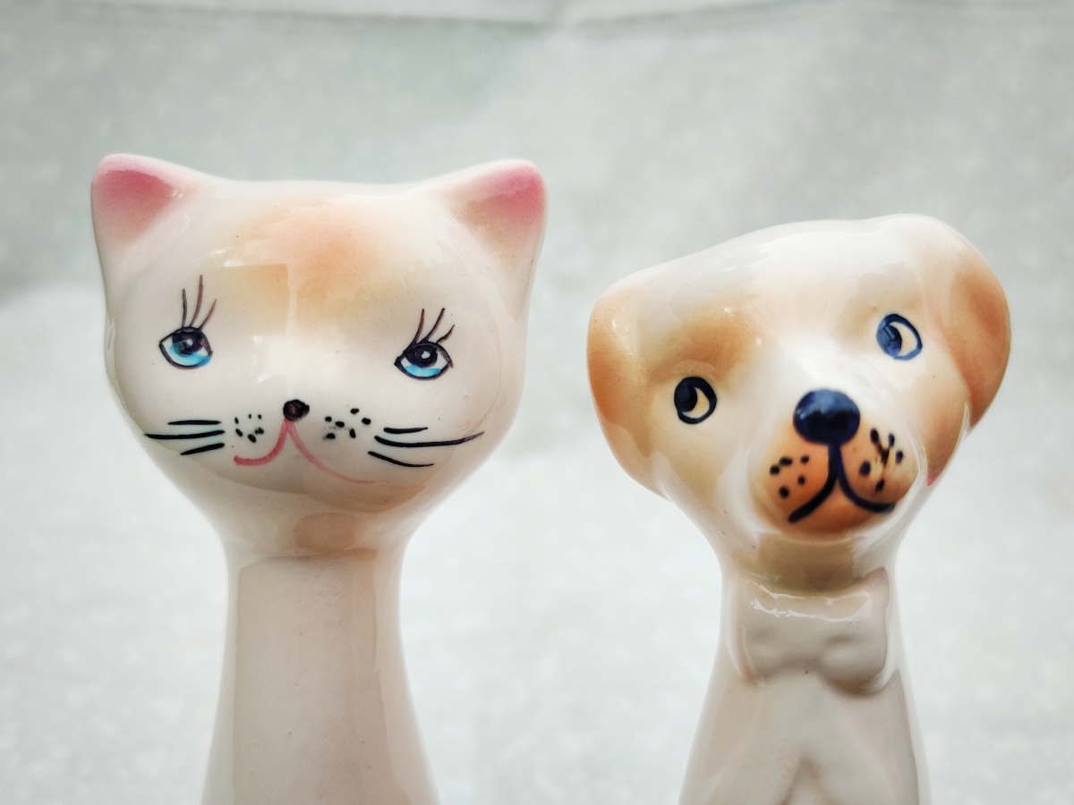 Keraaminen kissafiguuri ja keraaminen koirafiguuri.