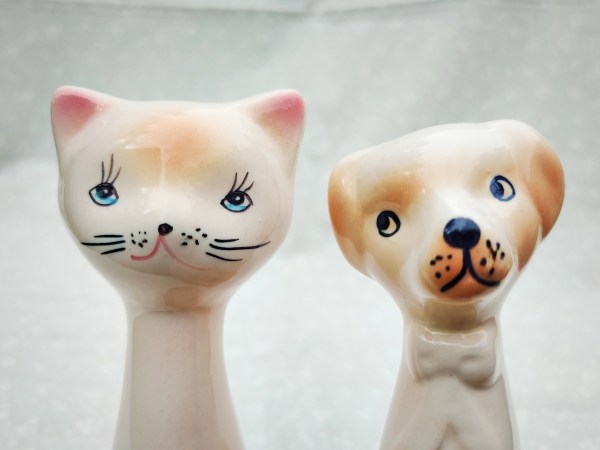 Keraaminen kissafiguuri ja keraaminen koirafiguuri.
