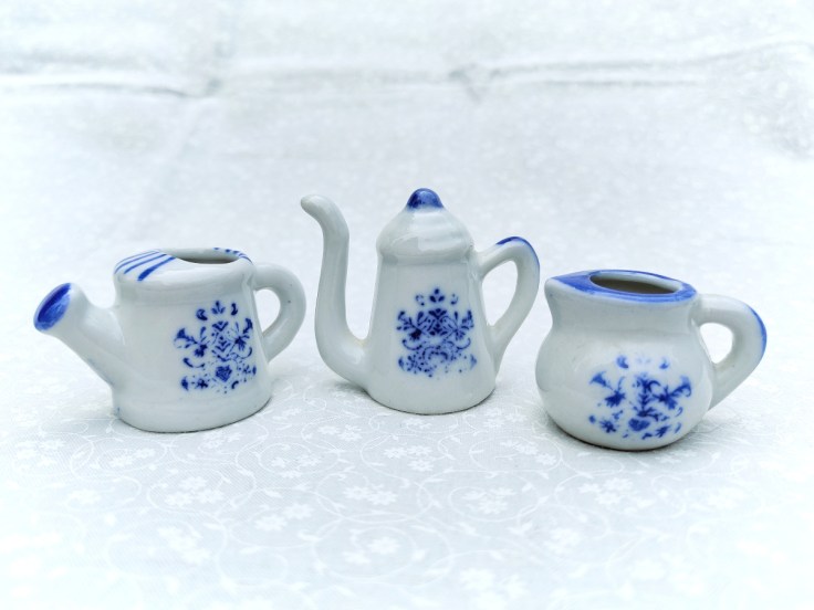 Kolme pientä keraamista kannua sinisillä koristekuvioilla.
