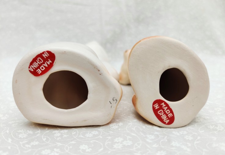 Made in China -lappuja keraamisten koristepatsaiden pohjassa. Toisen patsaan pohjassa lukee myös kynällä kirjoitettu hinta, 5 markkaa.