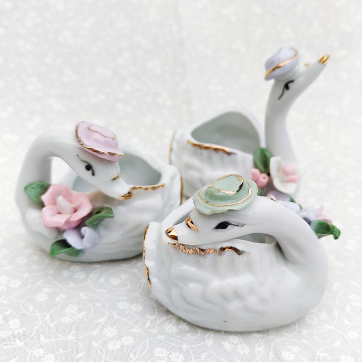 Keraamisia kukkakoristeisia joutsenen muotoisia kuppeja.