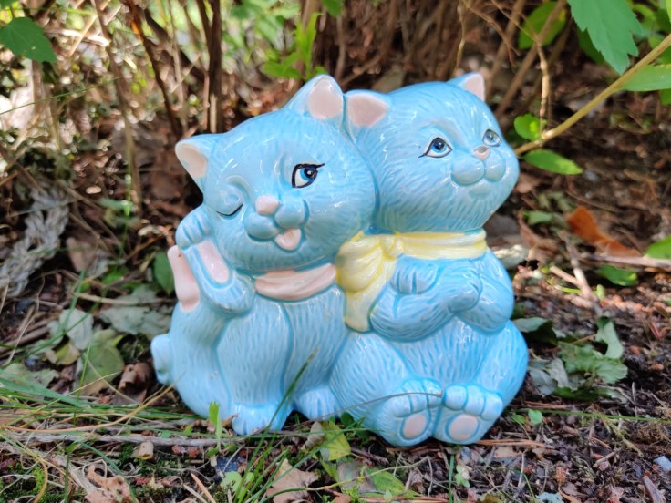 Keraaminen kahta kissaa esittävä kolikkopankki.