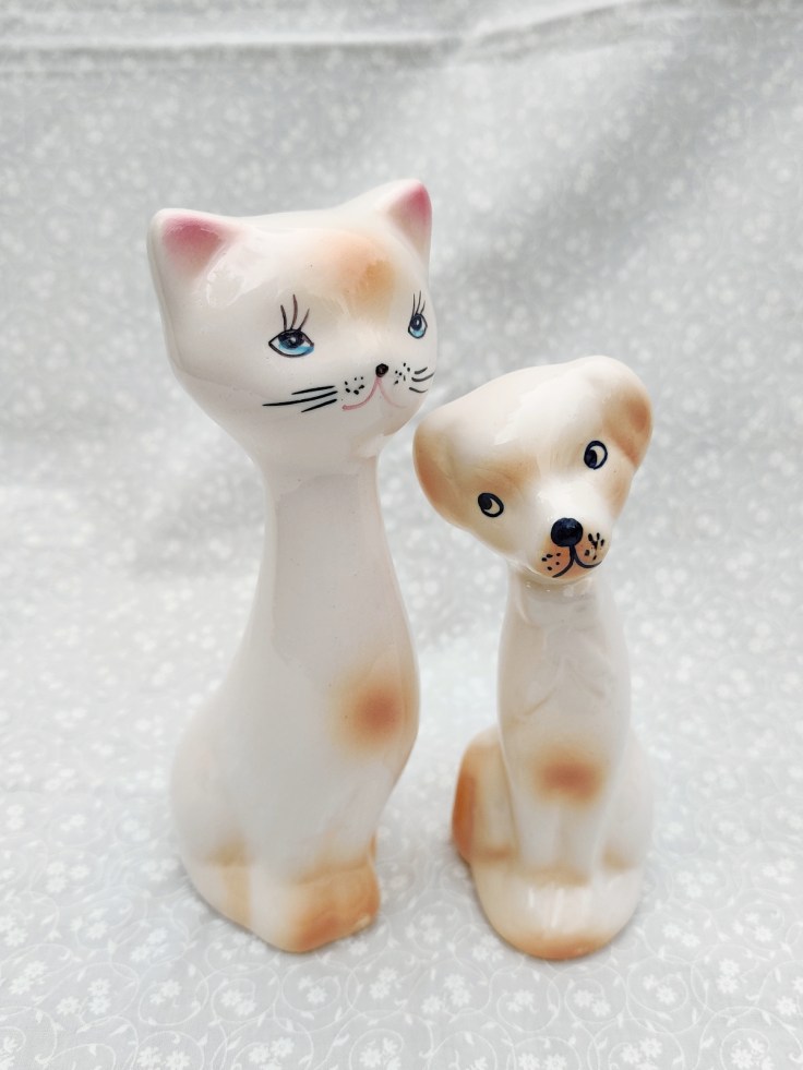 Keraaminen pitkä kissafiguuri ja keraaminen pitkä koirafiguuri.