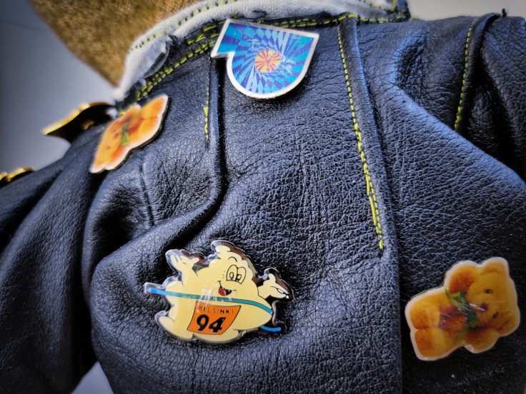 Nuken nahkatakki, jossa on kiinni monta pinssiä 1990-luvulta. Yksityiskohta.