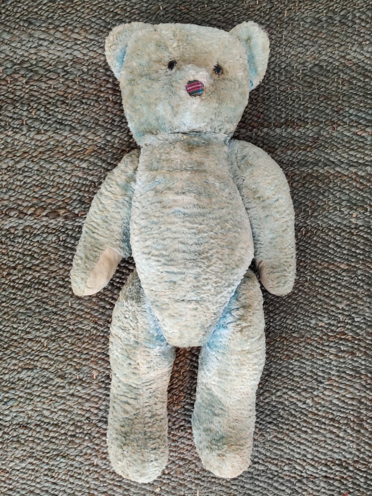 Iso vaaleansininen oljilla täytetty nalle 1950-luvulta, kuvattu edestä.