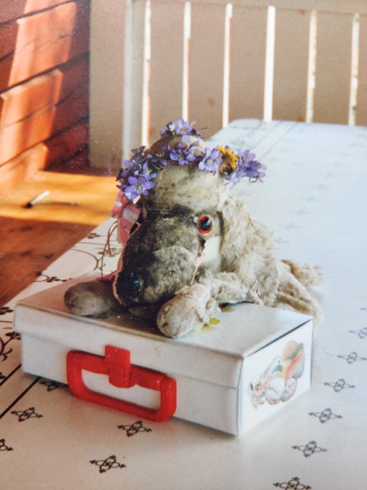 Vuonna 1994 kuvattu valokuva, jossa on yöpuvun säilytykseen tarkoitettu koiran muotoinen pussi 1950-luvulta. Koira nojailee muovisalkkuun, jonka sisällä on Rölli seikkailee -nimisiä kuunnelmia C-kaseteilla.