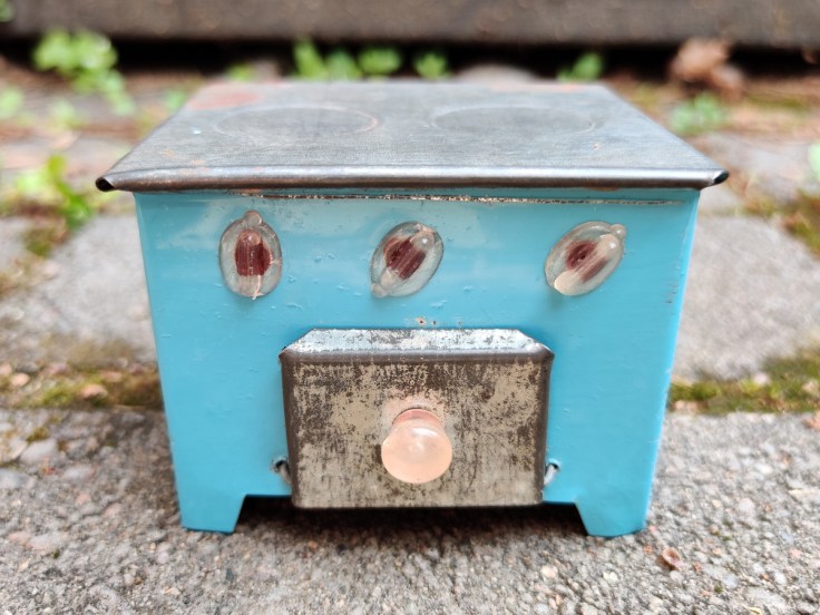 Peltinen nukkekodin hella 1950-luvulta edestä kuvattuna.