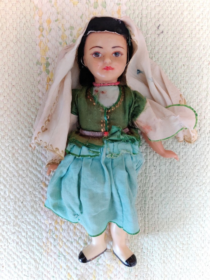 Kansallispukuinen nukke 1960-luvulta kuvattuna edestä.