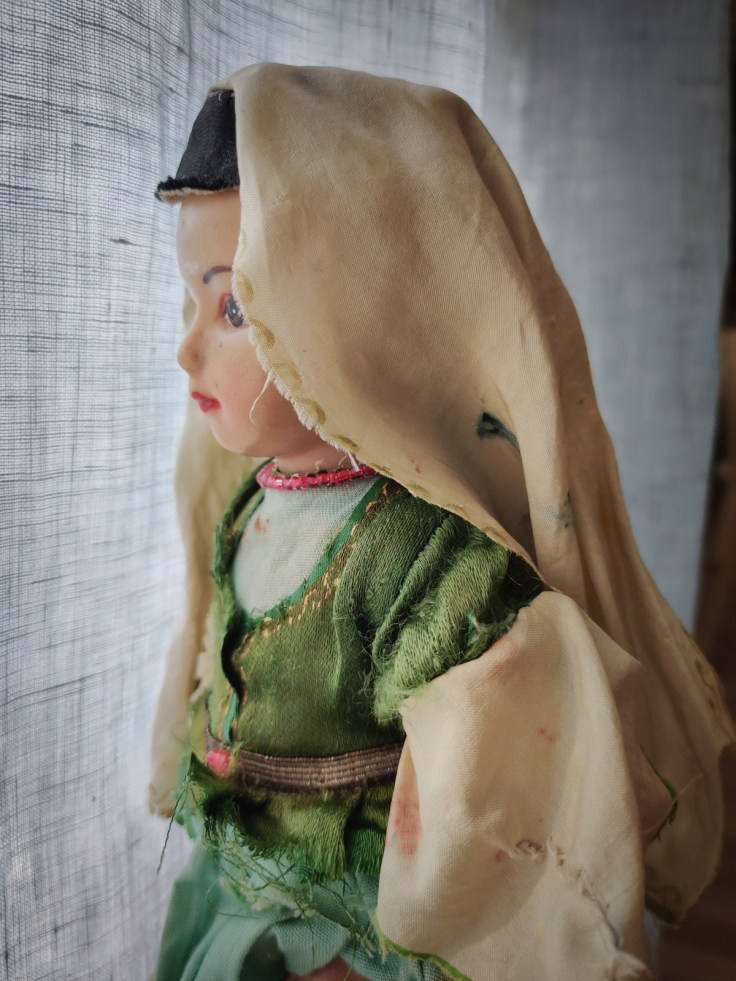 Kansallispukuinen nukke 1960-luvulta, ylävartalo sivulta.