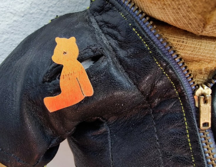 Nuken nahkatakki, jossa on nalle-pinssi. Yksityiskohta.